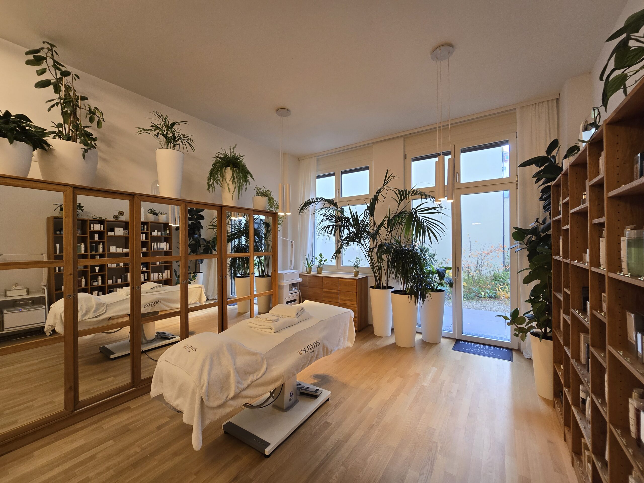 Der Salon von Mario Goldinger: helle Behandlungsliege, Holzregale und viele Pflanzen